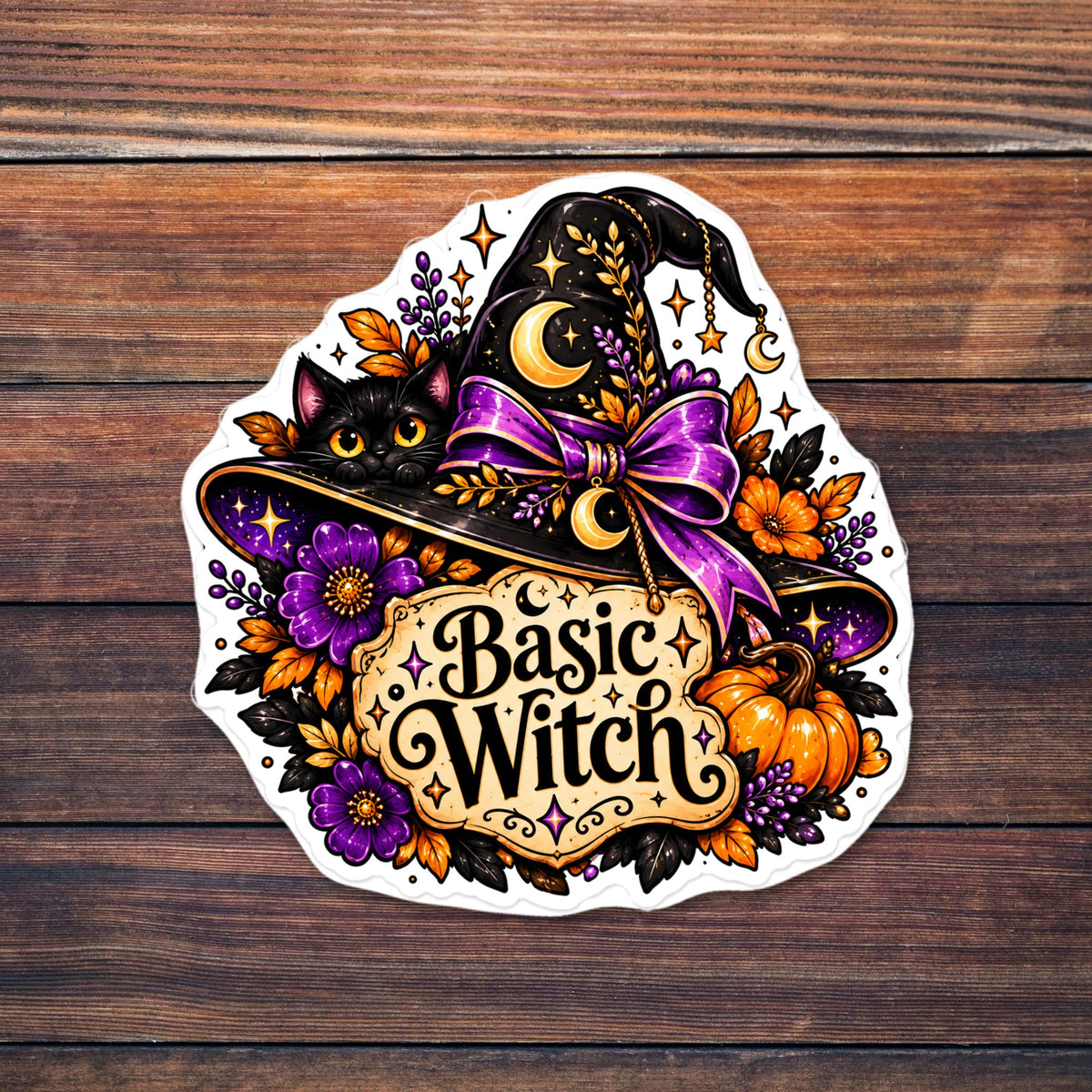 Illustrated sticker of a black cat peeking over the brim of a black witch hat with a purple bow and gold crescent moon charms, surrounded by purple and orange flowers, autumn leaves, lavender and a pumpkin, with a parchment sign reading Basic Witch. shown on a wooden table