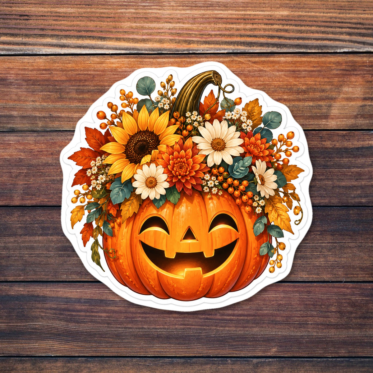 Smiling carved jack-o'-lantern topped with a floral arrangement of a sunflower, white daisies, orange chrysanthemums, berries and autumn leaves, with a white die-cut border shown on a wooden table